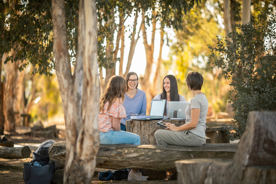 Students gathered around a table at CSU, one of the best universities in regional Australia