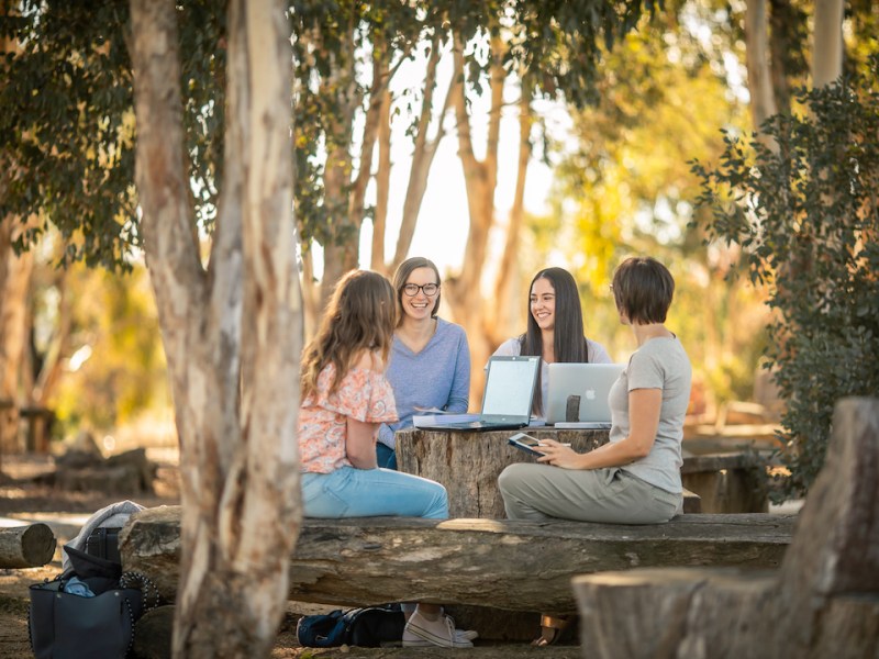 Students gathered around a table at CSU, one of the best universities in regional Australia